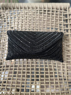 Front view of the black Grainline flap bag, illustrating a monochromatic, sophisticated design.
