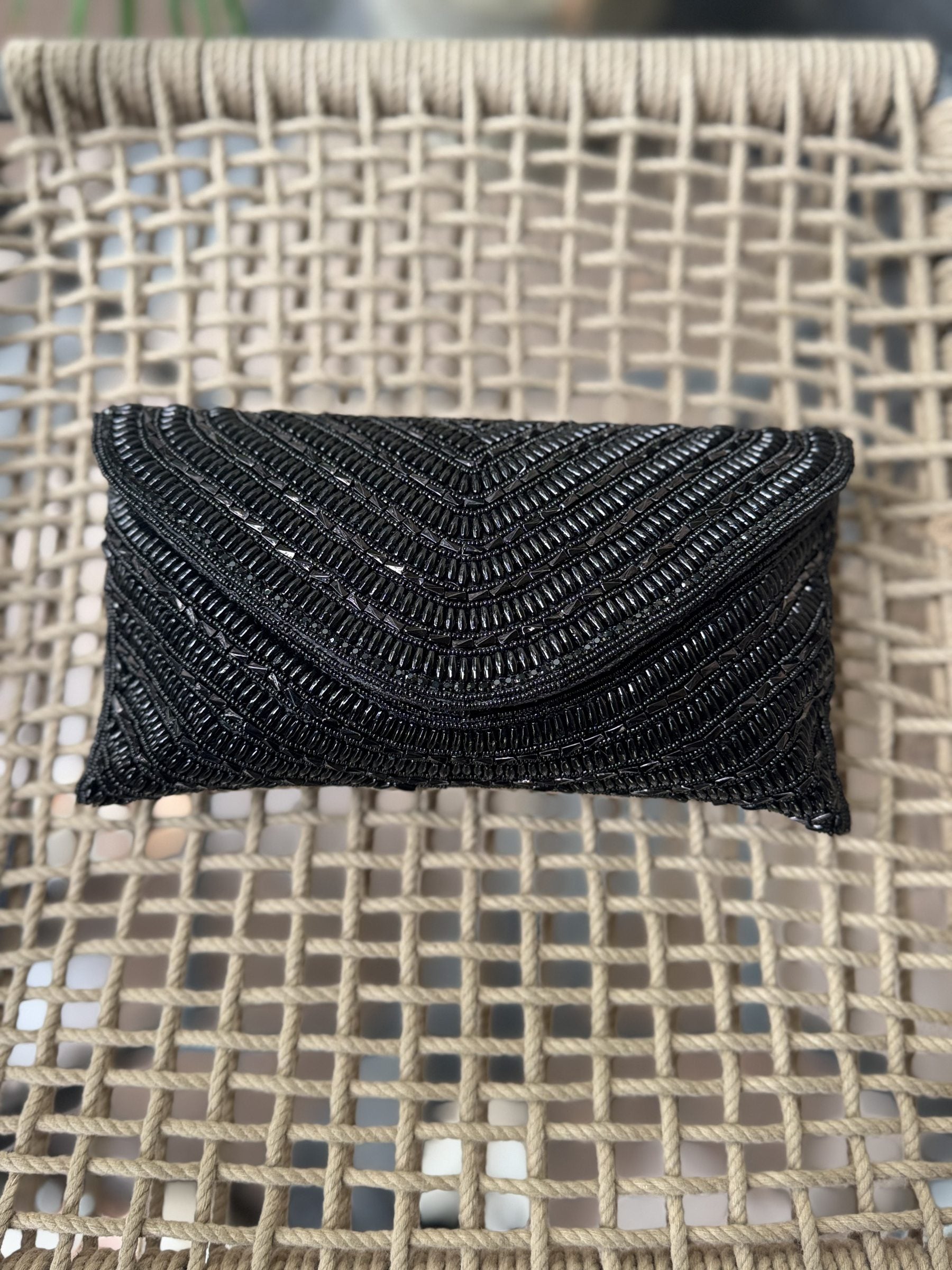 Front view of the black Grainline flap bag, illustrating a monochromatic, sophisticated design.