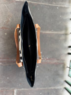 Detail shot of the double reinforced stitching at the handle attachments of the faux leather bag.
