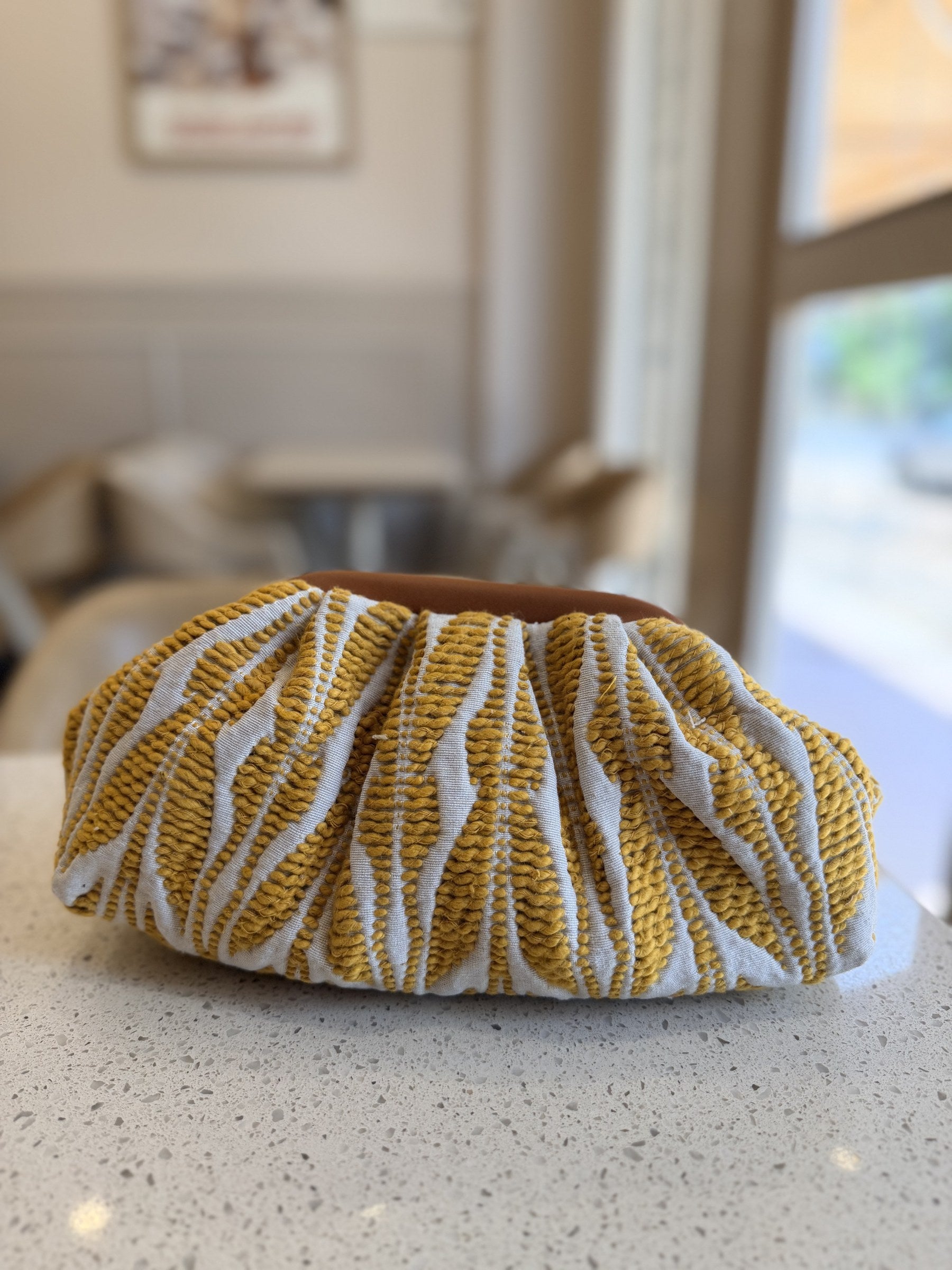Gold-tone loop and clasp detail on the jacquard fabric loops.