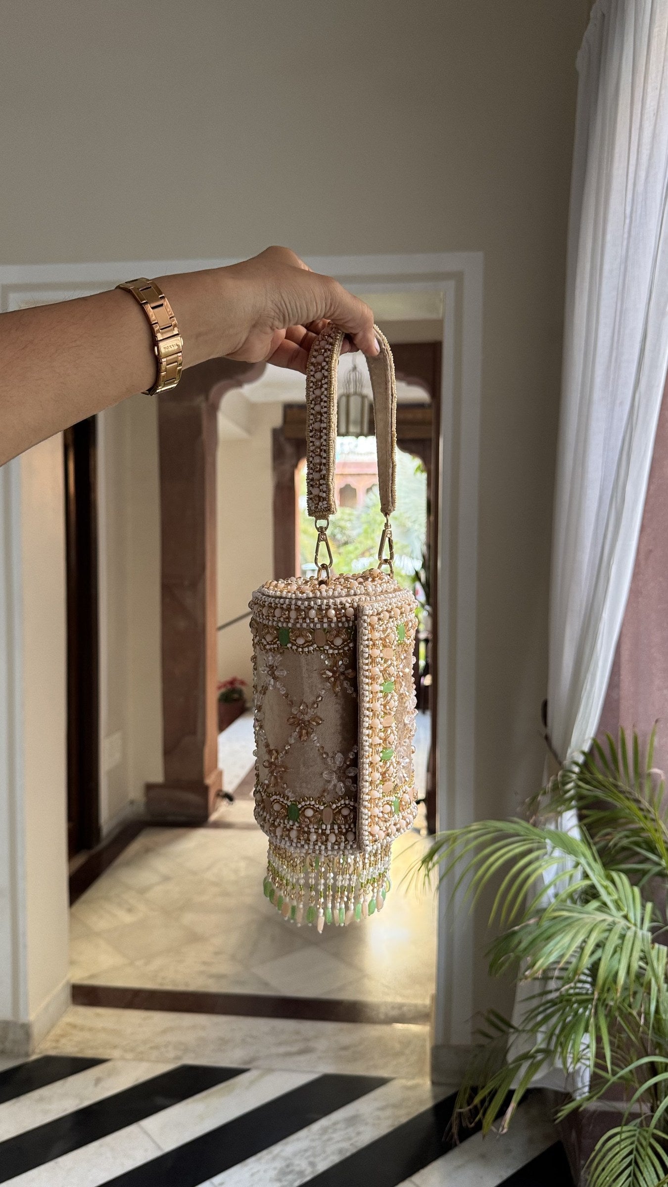 The Jadau Dreams Potli styled alongside a designer lehenga and gold bangles.
