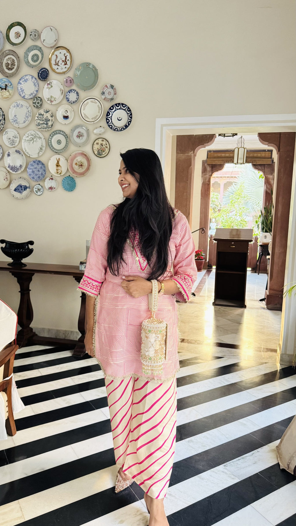 The Jadau Dreams Potli hanging from its gold-tone metal sling chain.