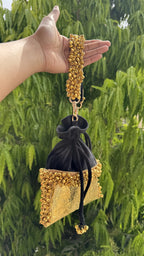 The Jhankar velvet potli paired with a traditional gold lehenga, showcasing its elegant drape.