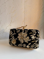 Lifestyle layout of the Kashi velvet clutch next to silk coordinates and wedding jewelry.