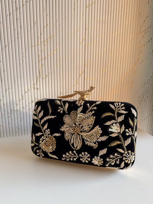 Lifestyle layout of the Kashi velvet clutch next to silk coordinates and wedding jewelry.