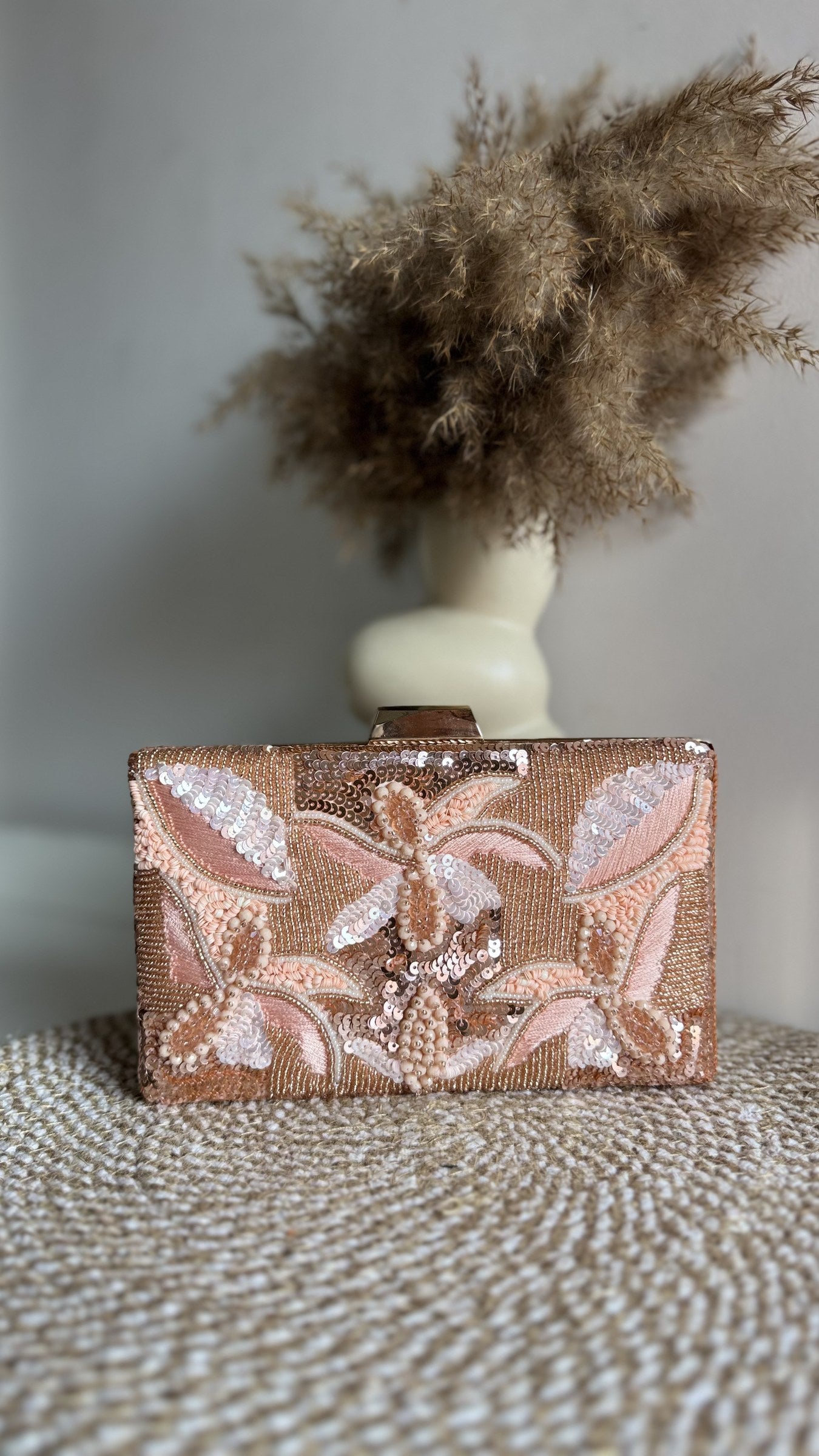 Side profile of the structured Kiara clutch showing its depth and gold borders.