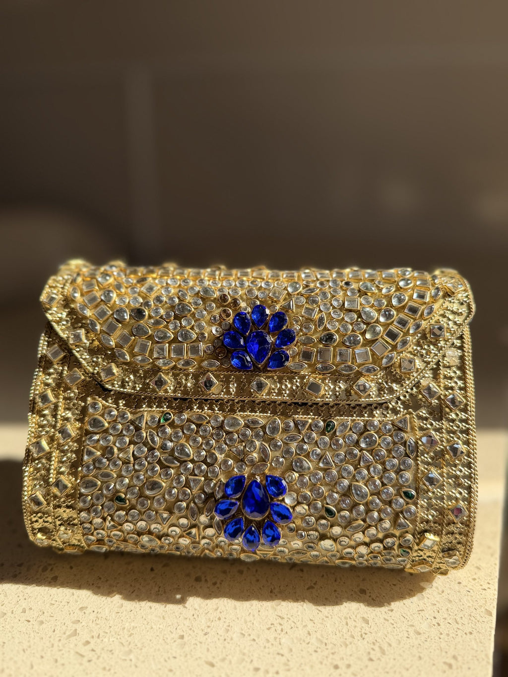 Detailed view of the hand-set Kundan stones arranged in floral patterns on red velvet.