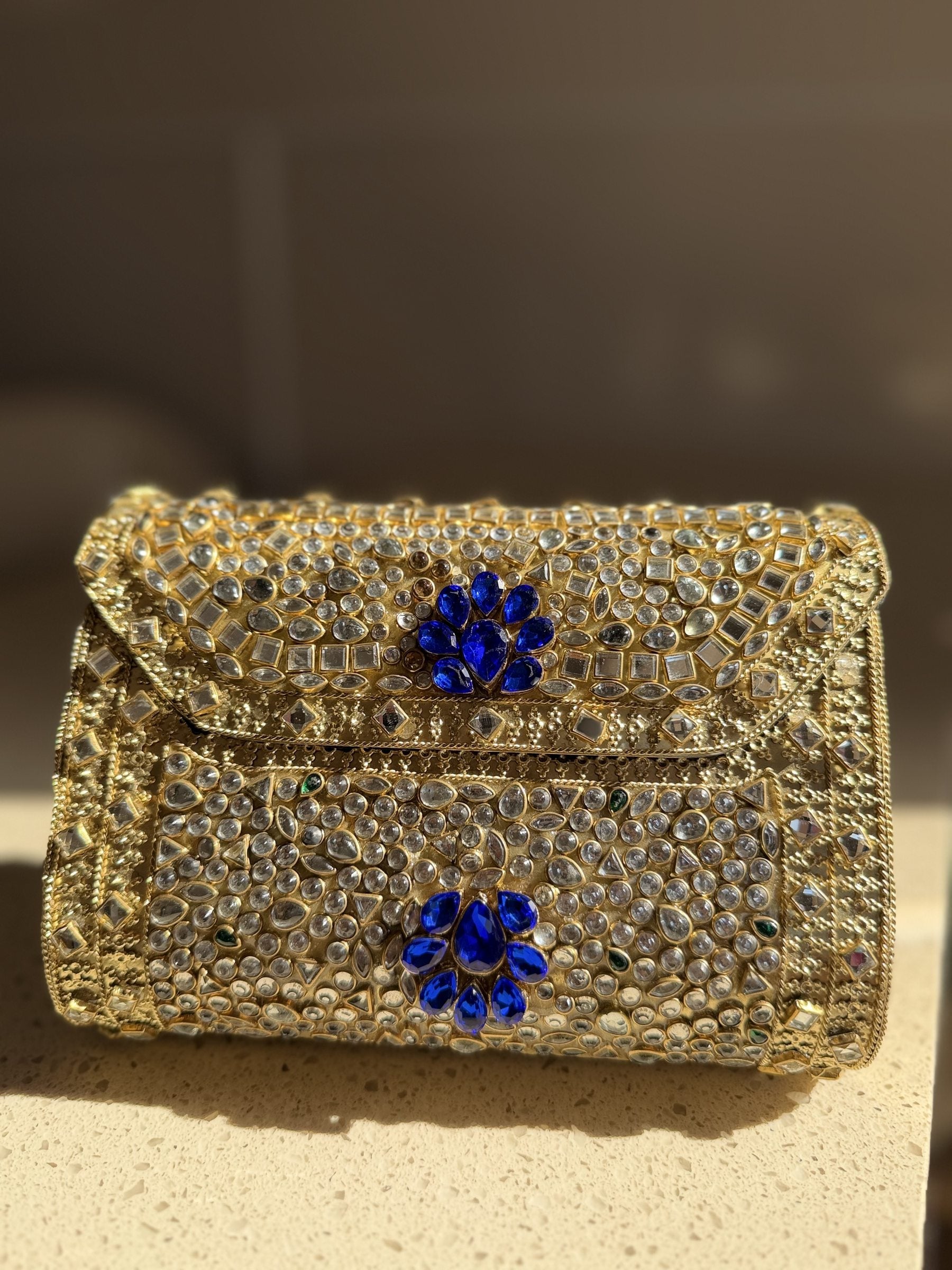 Detailed view of the hand-set Kundan stones arranged in floral patterns on red velvet.
