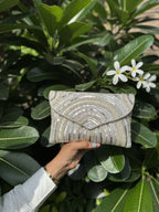 Lifestyle layout of the Leher Waves flap bag next to traditional wedding attire and jewelry coordinates.