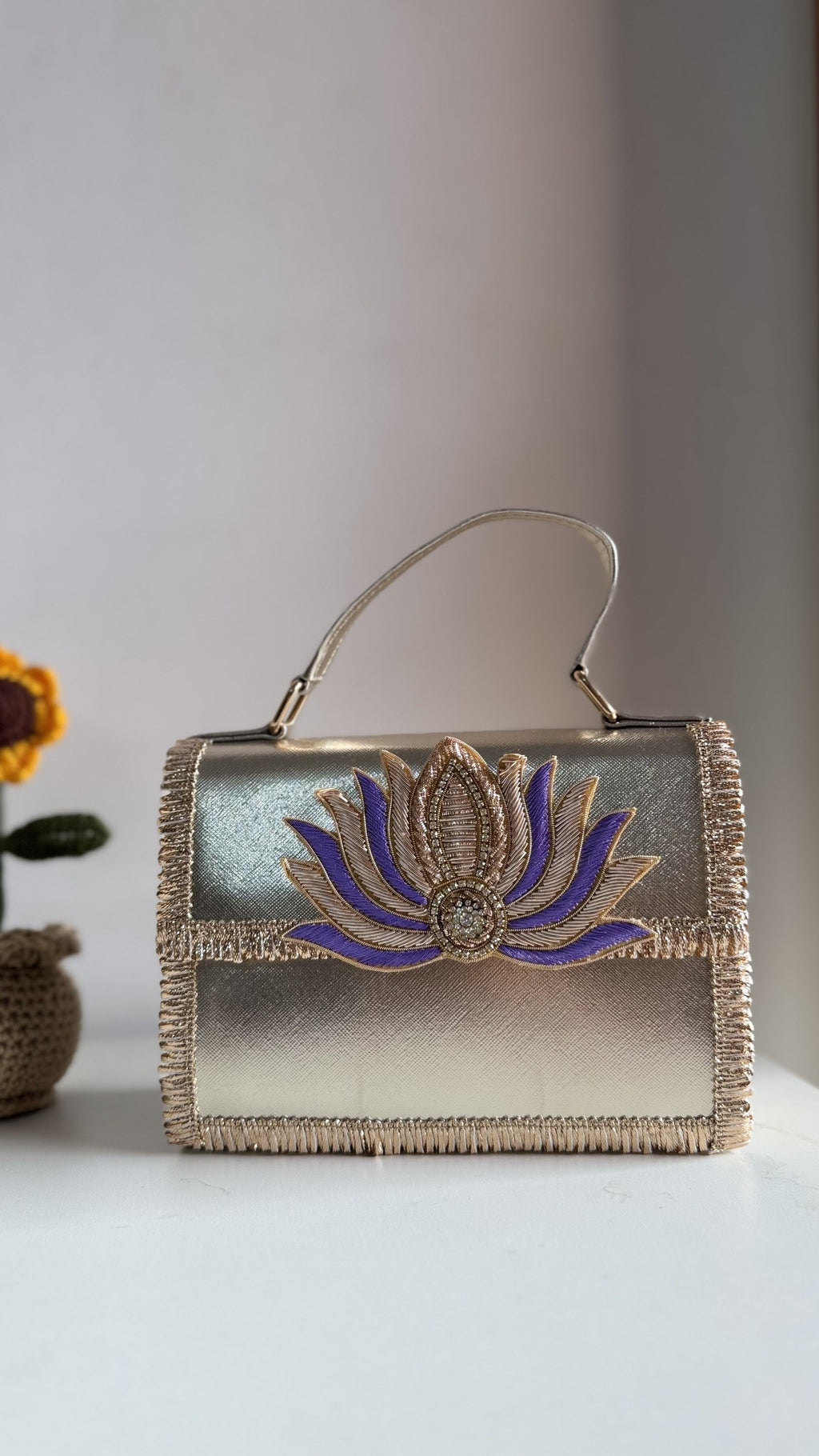 Lotus Treasure clutch in ruby red, illustrating the color panel contrast against the gold trim.