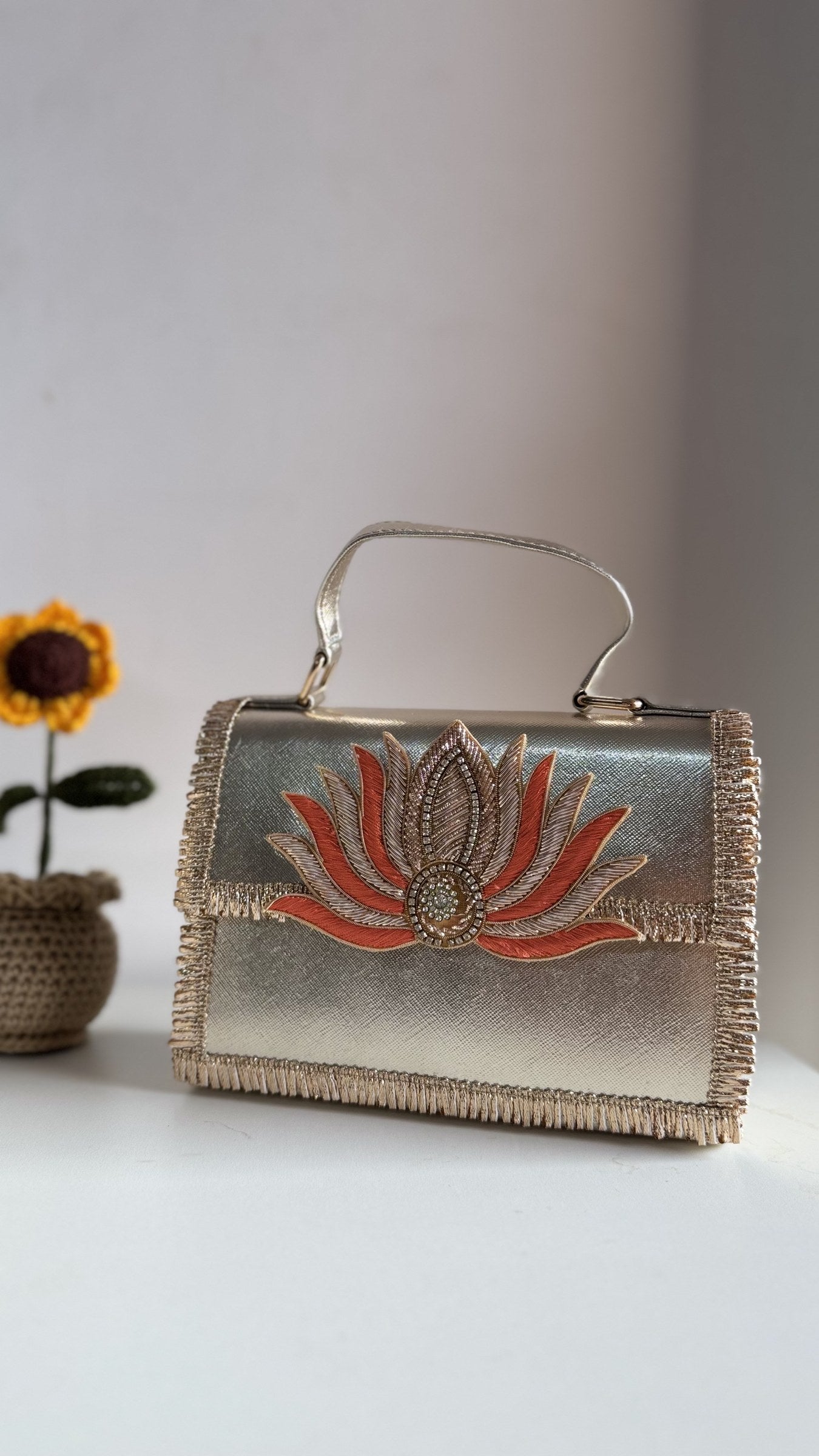 Lotus Treasure clutch in emerald green, showing the deep green panel and gold details.