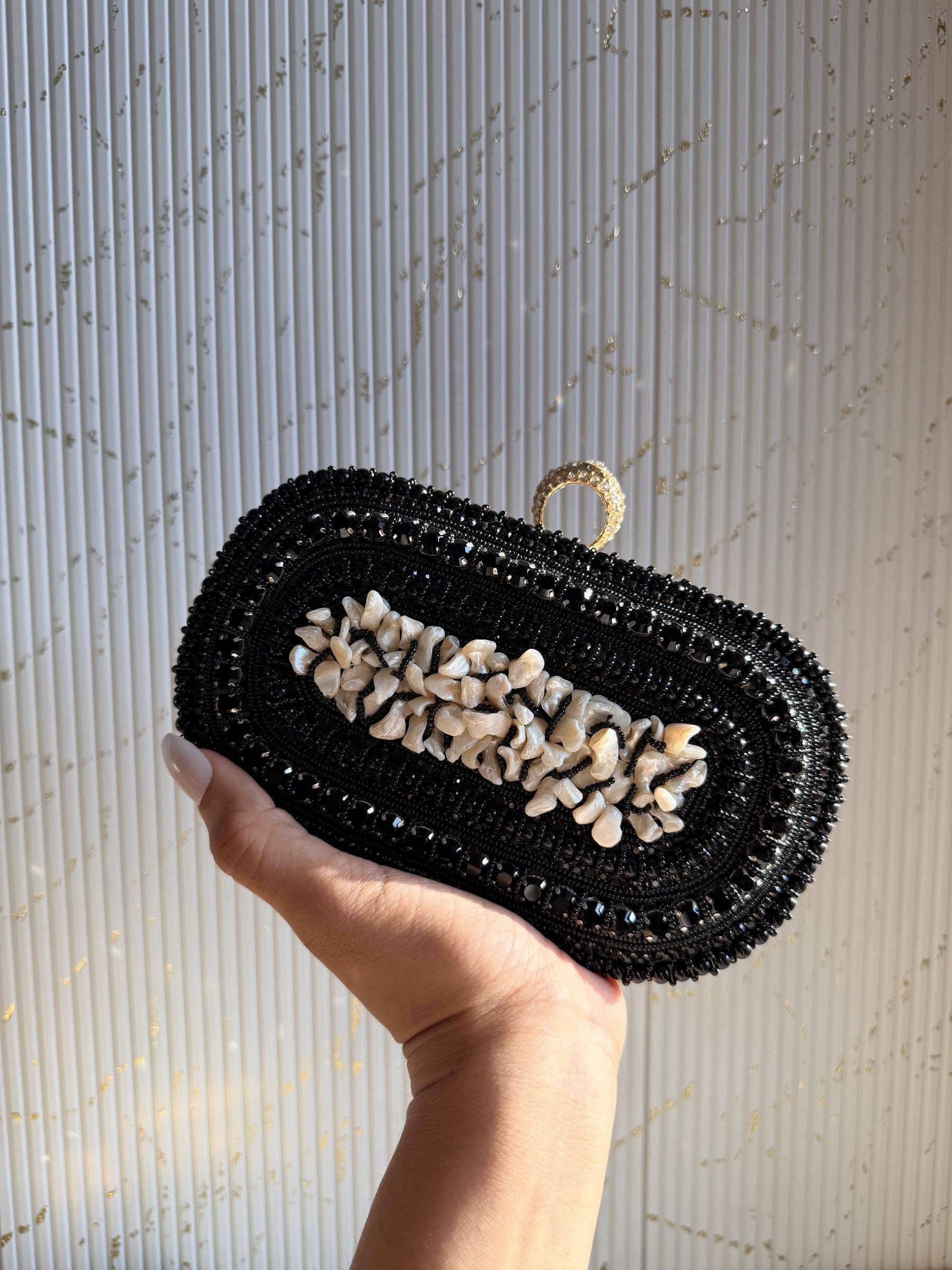 Luxe Grip jute box clutch displaying its natural jute texture, cream pearls, and gold clasp.