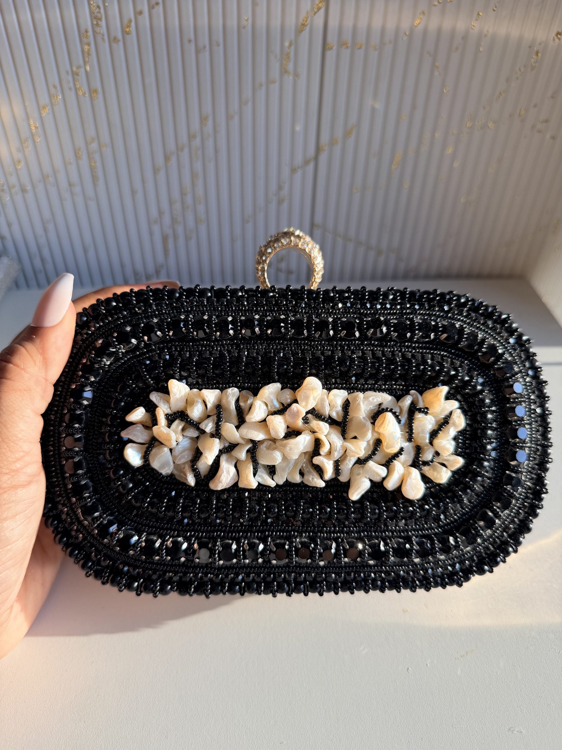 Front view of the Luxe Grip clutch, showcasing the rows of hand-set pearls.