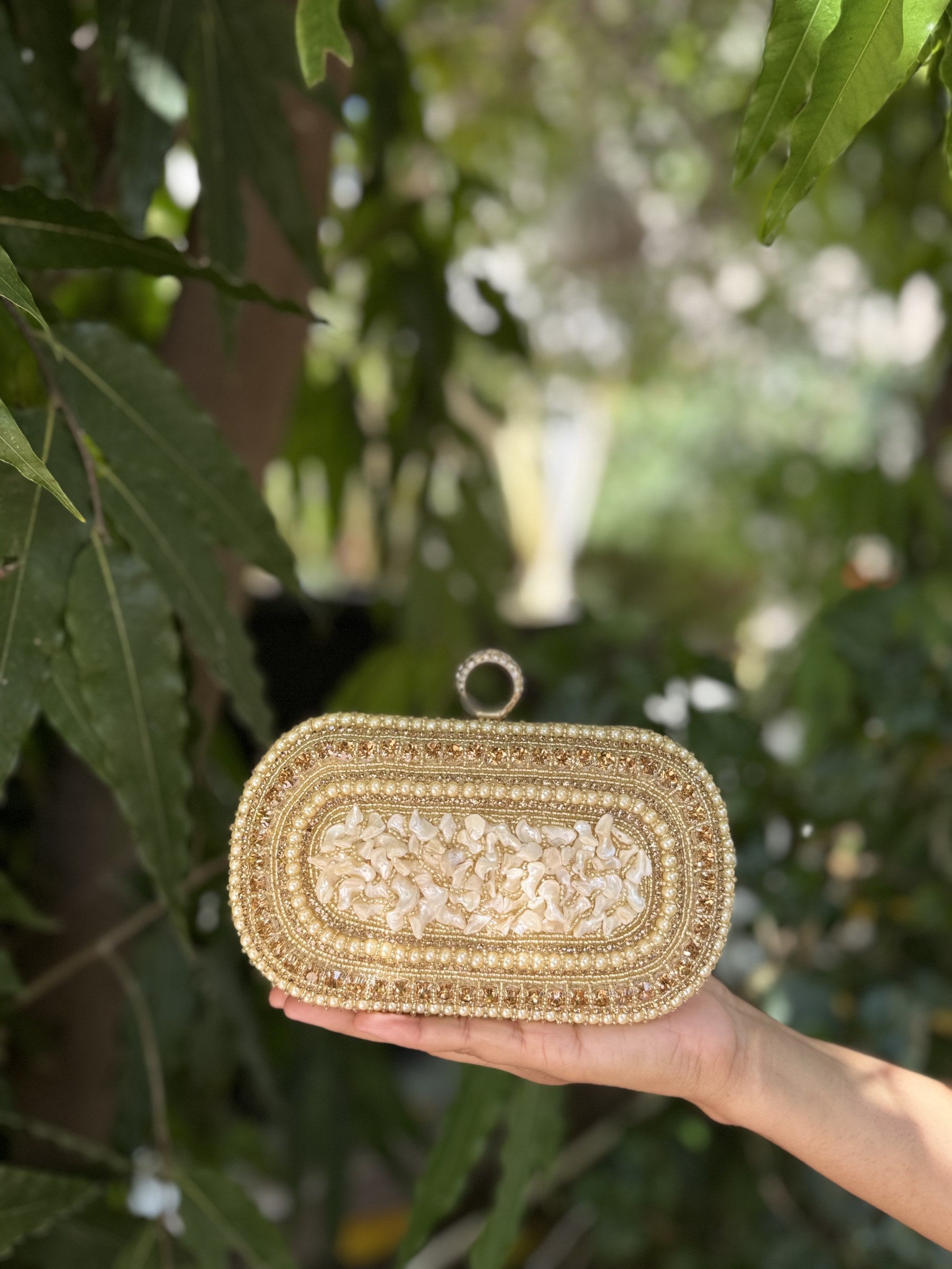 Angled view of the Luxe Grip clutch highlighting the handcrafted pearl lines.