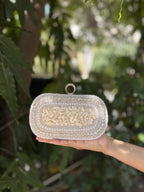 The Luxe Grip clutch held handheld, illustrating its organic evening style.