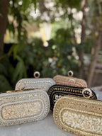 The Luxe Grip clutch styled over the shoulder with its gold-tone chain.