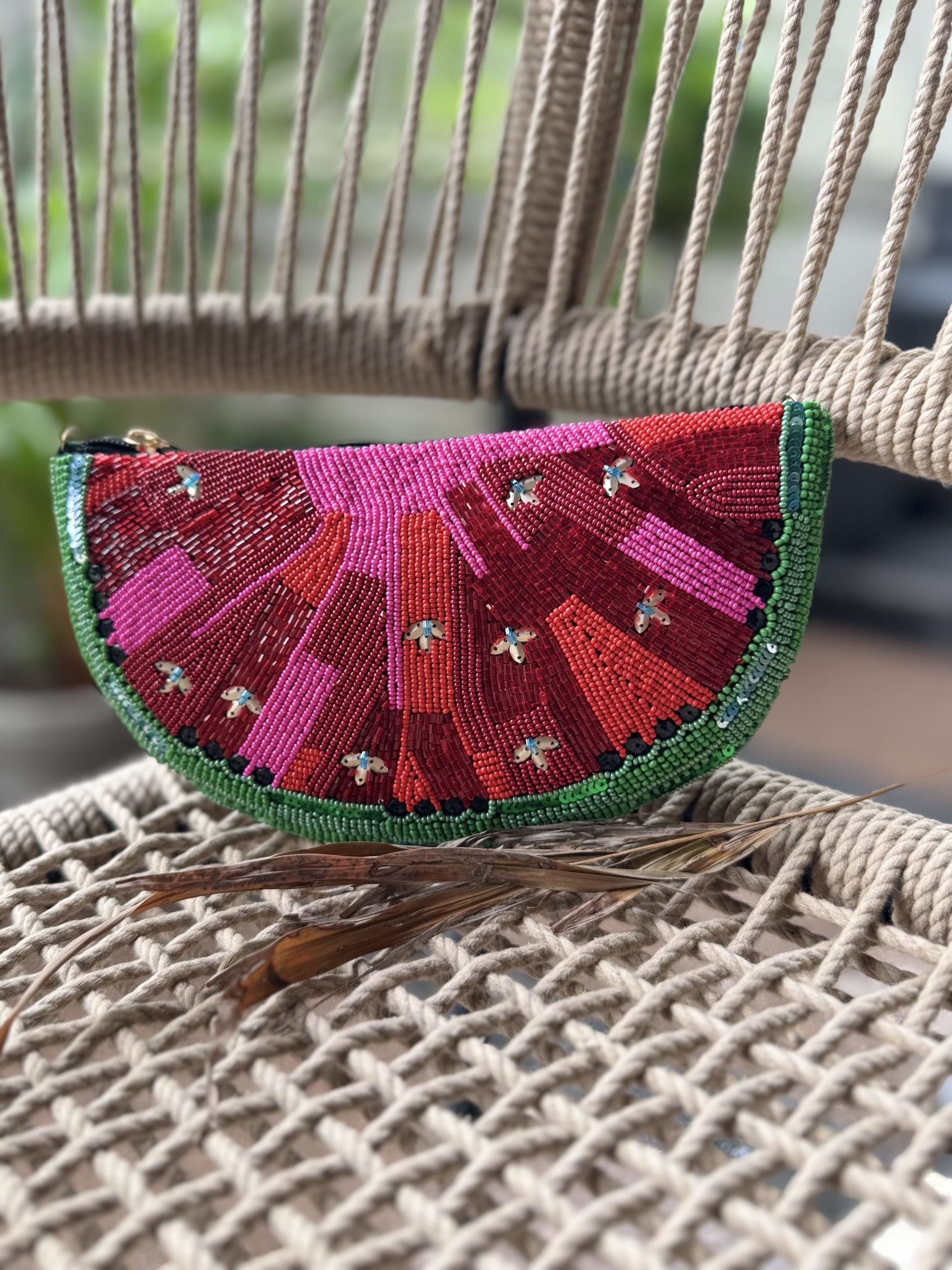 Front view of the Melon Mood Watermelon Clutch, showcasing its semi-circular slice shape and seed embroidery.