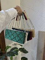 Flat lay of the Midnight Mosaic bag with gold jewelry and a passport organizer.