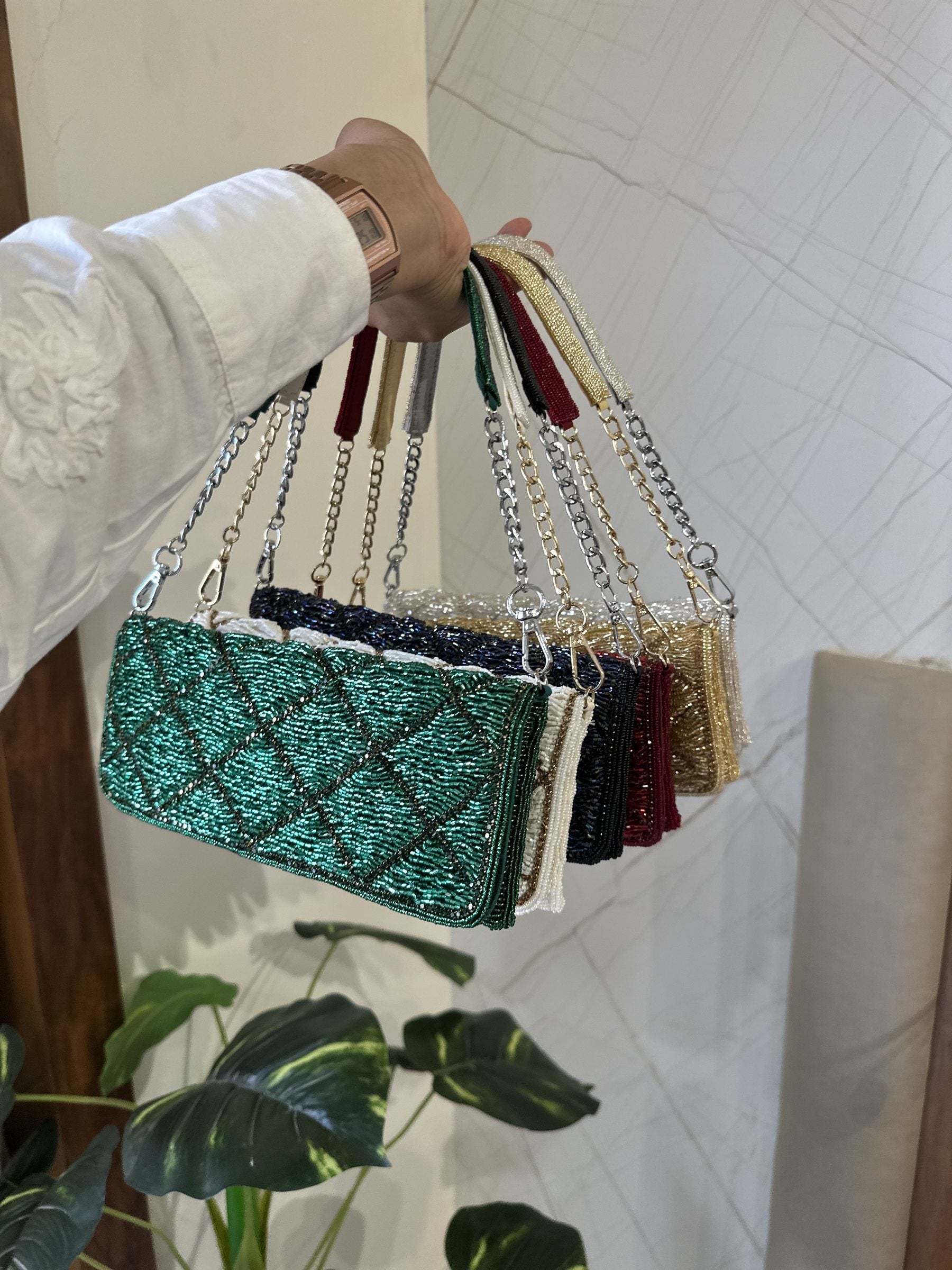 Flat lay of the Midnight Mosaic bag with gold jewelry and a passport organizer.