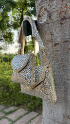 Open view of the Mini Saanjh handbag displaying the fabric lining and metal hinge.