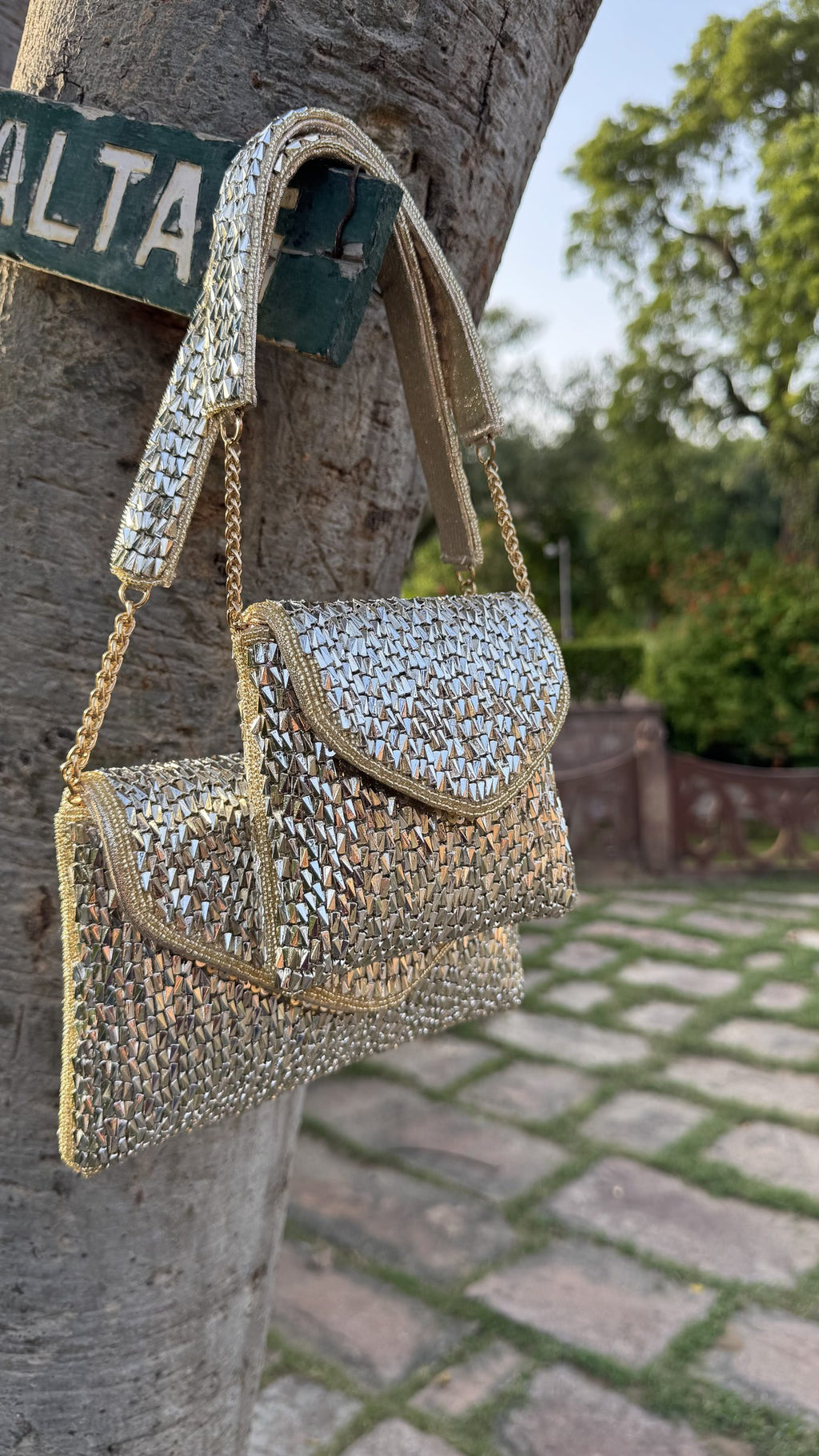 The Mini Saanjh clutch styled handheld, highlighting its small size next to festive outfits.