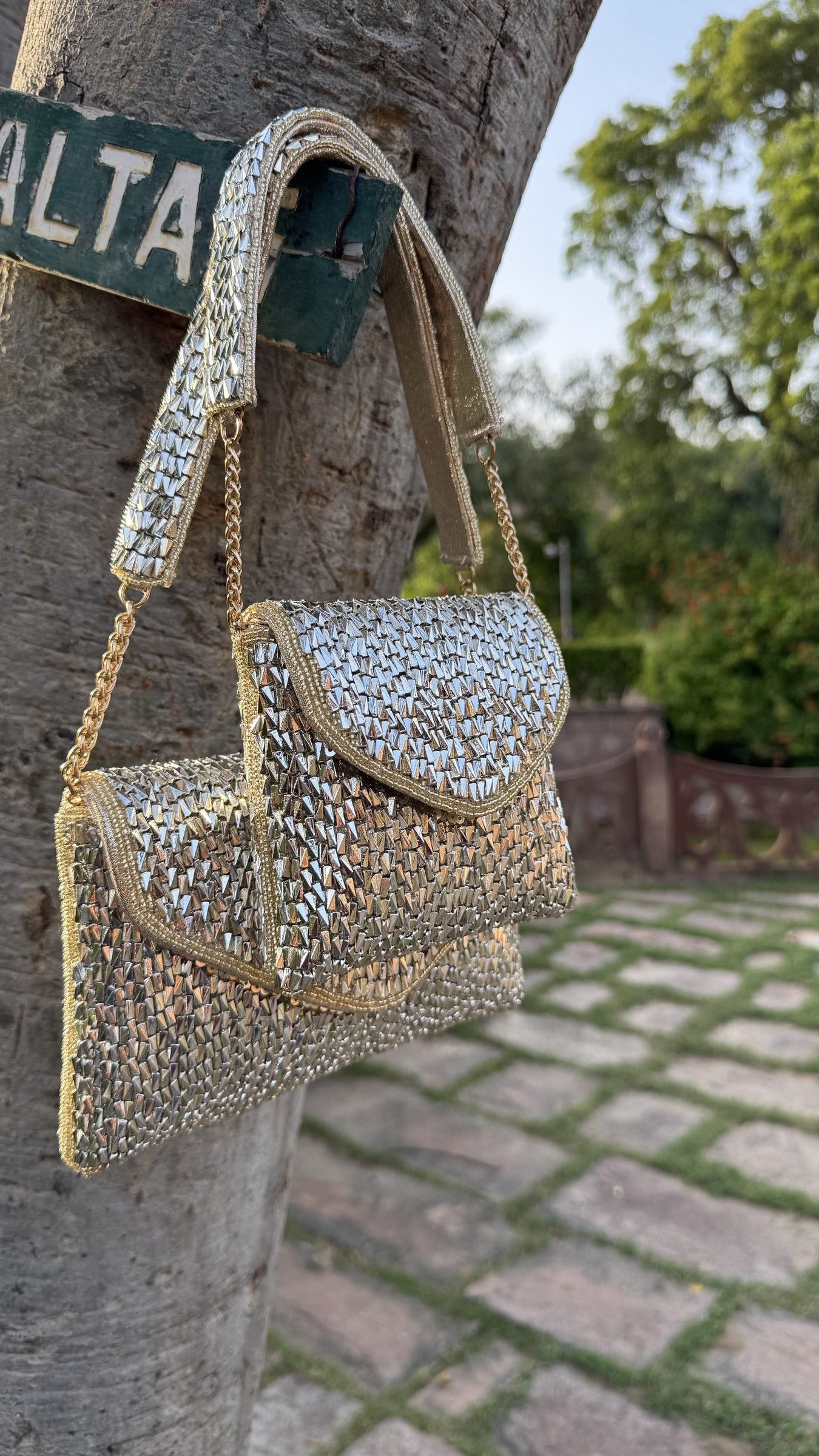 The Mini Saanjh clutch styled handheld, highlighting its small size next to festive outfits.