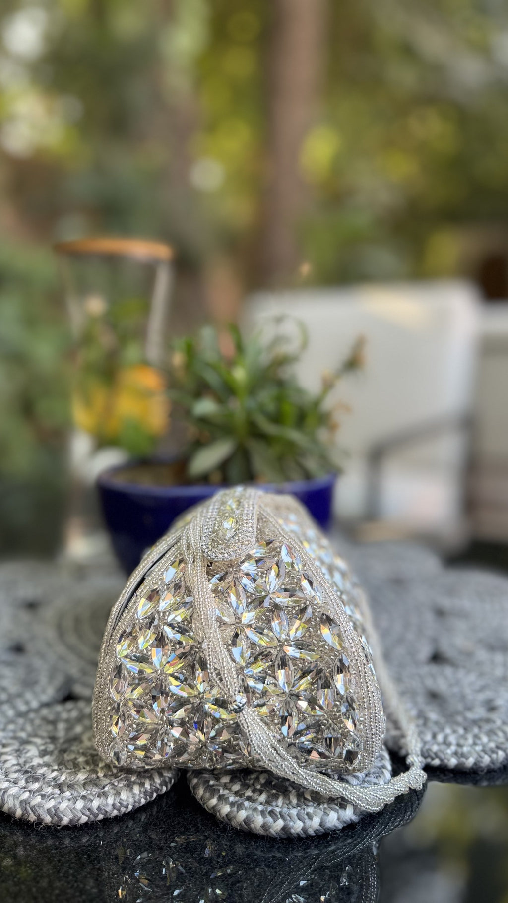 Handheld view showing the compact scale of the Mini Trunk Potli relative to evening wear.