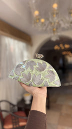 Detailed close-up of the three-dimensional gold petals rising from the mint enamel base.