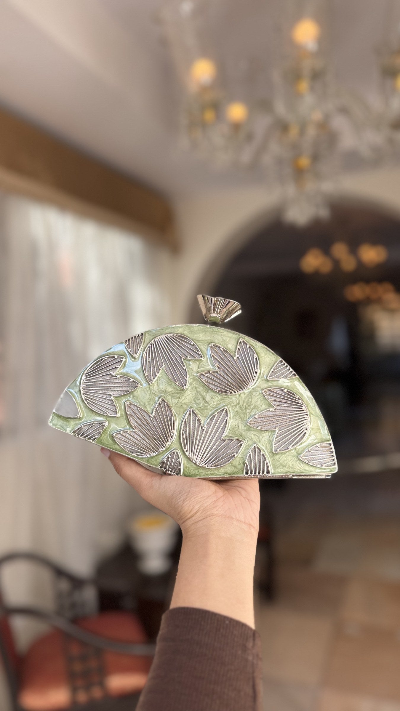 Detailed close-up of the three-dimensional gold petals rising from the mint enamel base.
