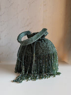 Front view of the Mira Suede Embroidered Potli, highlighting the dense floral beadwork against charcoal suede.