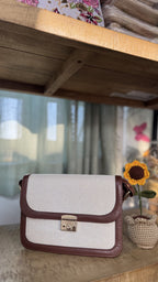 Close-up of the gold-tone buckle on the adjustable brown PU leather shoulder strap.