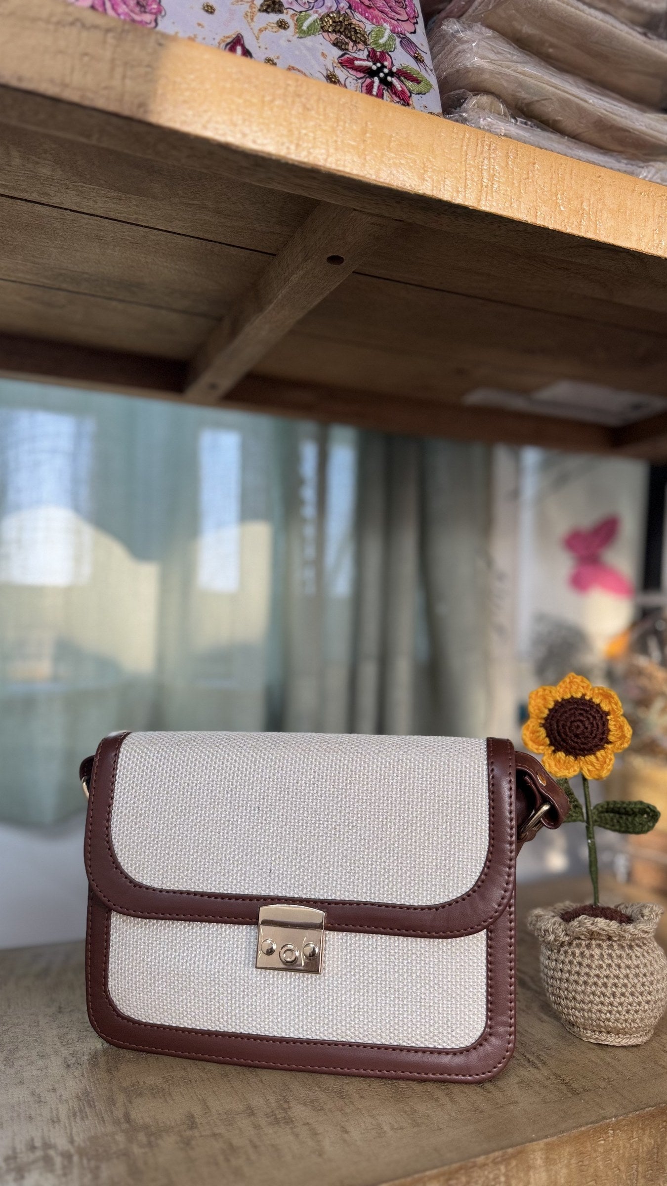 Close-up of the gold-tone buckle on the adjustable brown PU leather shoulder strap.