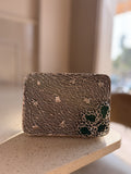 Molten Luxe brass clutch showing its gold surface and hand-set emerald-toned stones.