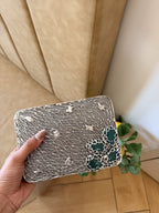 Side angle of the Molten Luxe clutch showing its structured gold borders and hinge.