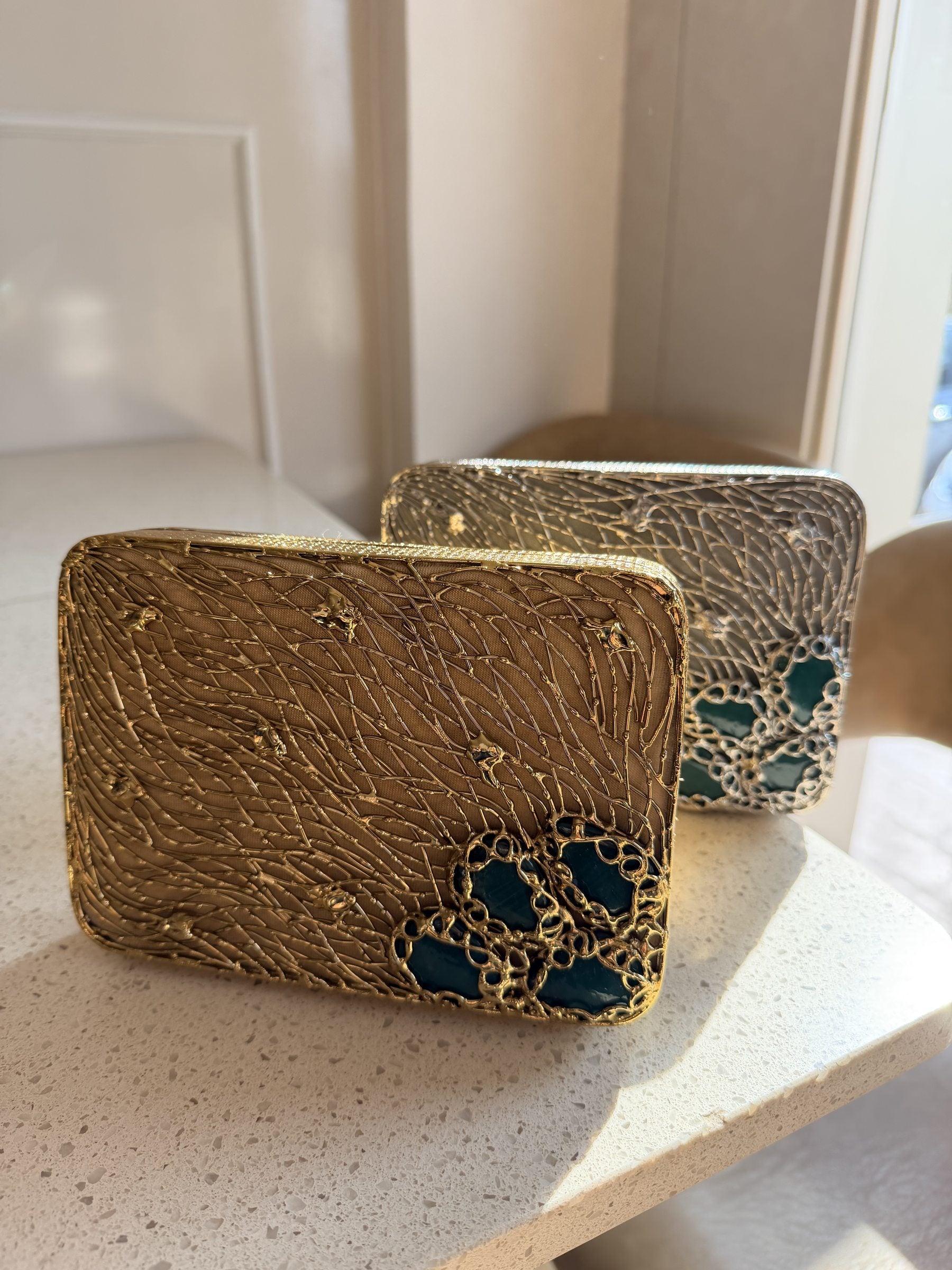 Open view of the Molten Luxe brass bag displaying its interior lining and secure clasp lock.