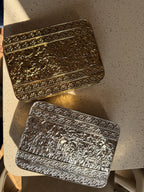 Lifestyle shot of the Molten Luxe clutch styled next to traditional gold jewelry and silk coordinates.