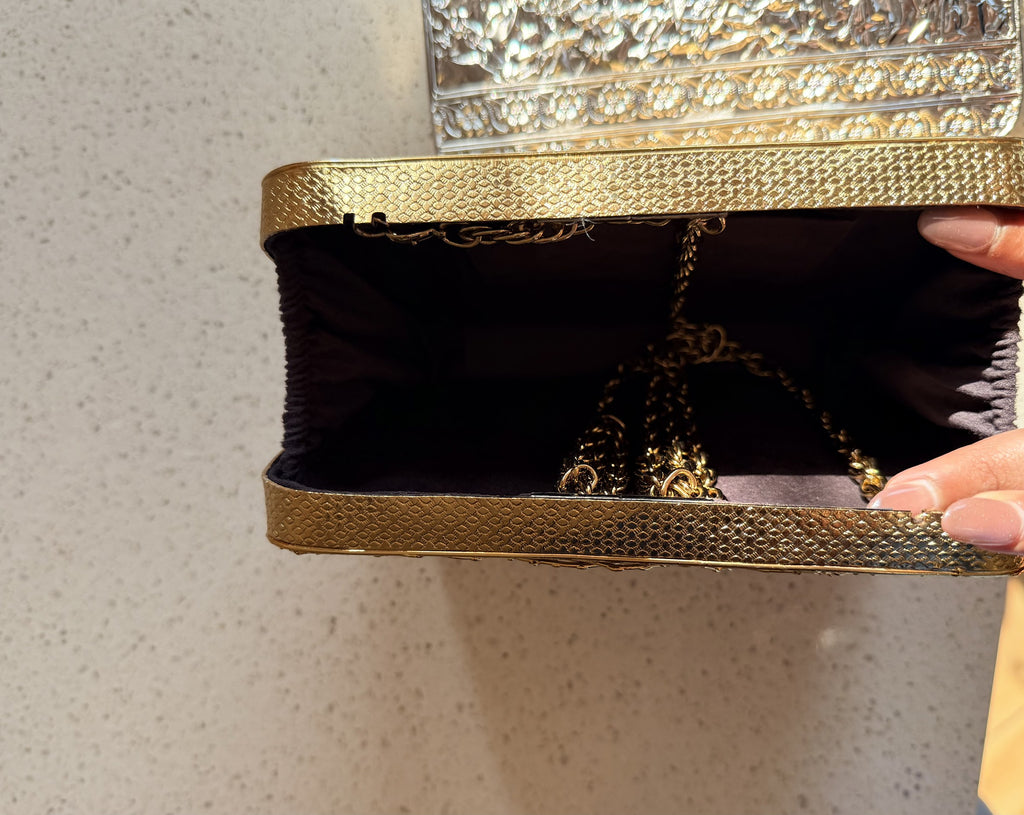 The Molten Luxe clutch held handheld, highlighting its jewel-like design and proportions.