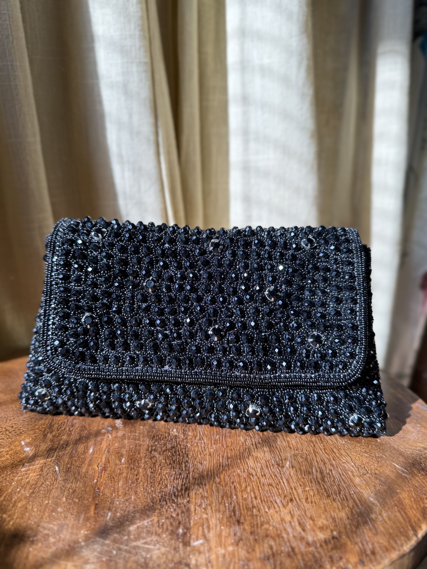 Open view of the Moonbeam Crystal handbag showing the secure magnetic snap and fabric-lined interior.