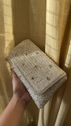 Lifestyle shot of the Moonbeam Crystal bag styled next to crystal jewelry and a silver gown.