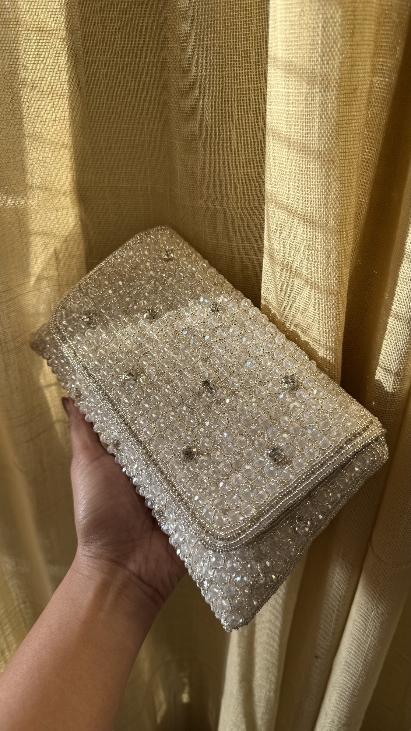 Lifestyle shot of the Moonbeam Crystal bag styled next to crystal jewelry and a silver gown.