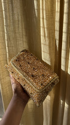 Angled view of the Moonbeam Crystal clutch with its metallic sling chain attached.