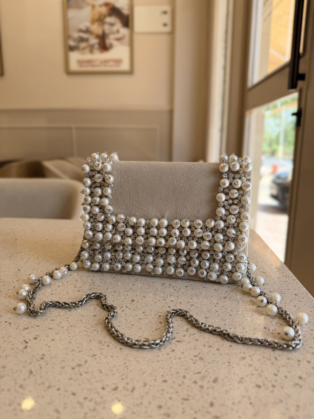 Side view of the Noir Pearl Edit clutch showing its slim profile and silver-tone clasp.