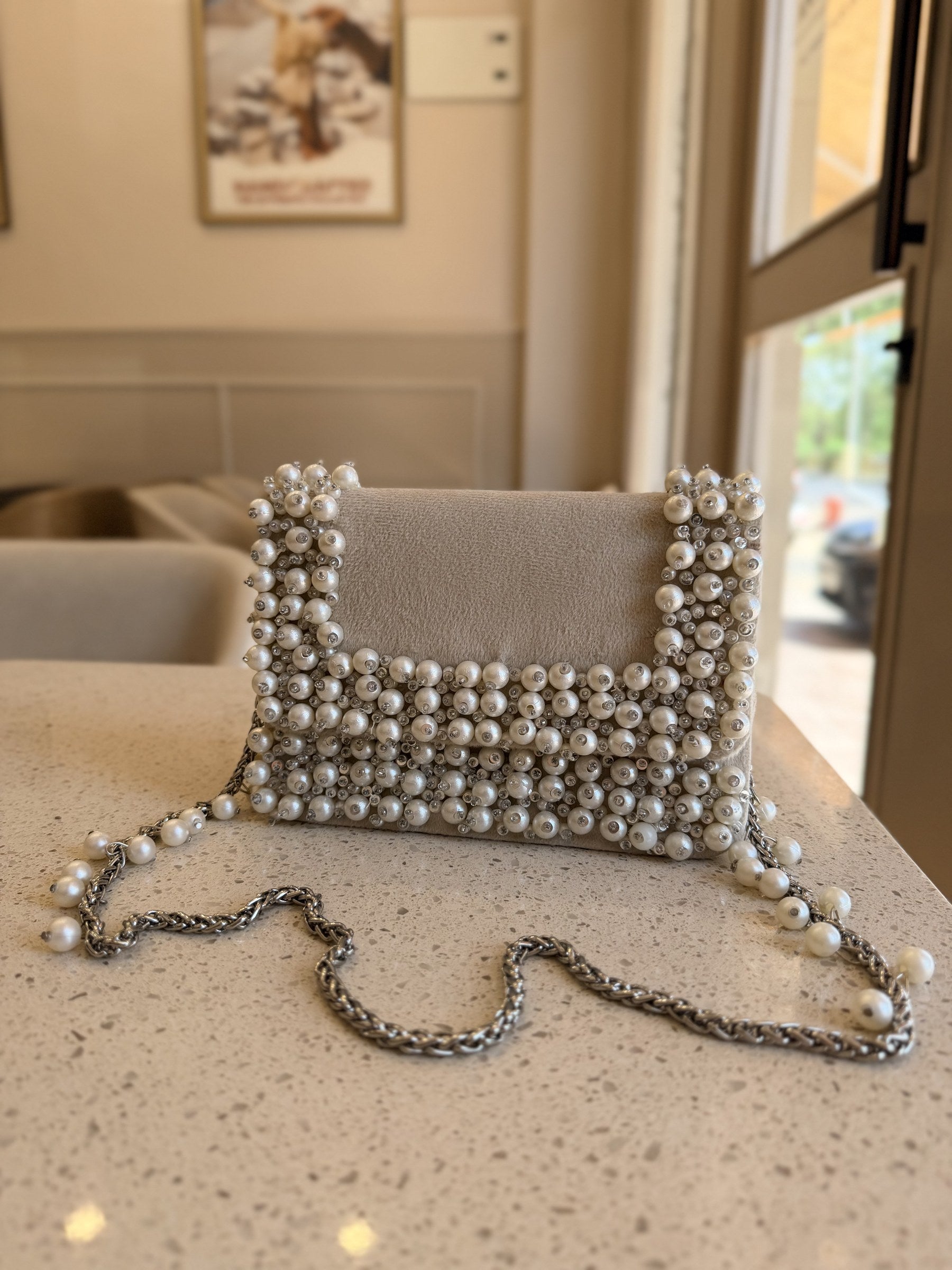 Side view of the Noir Pearl Edit clutch showing its slim profile and silver-tone clasp.