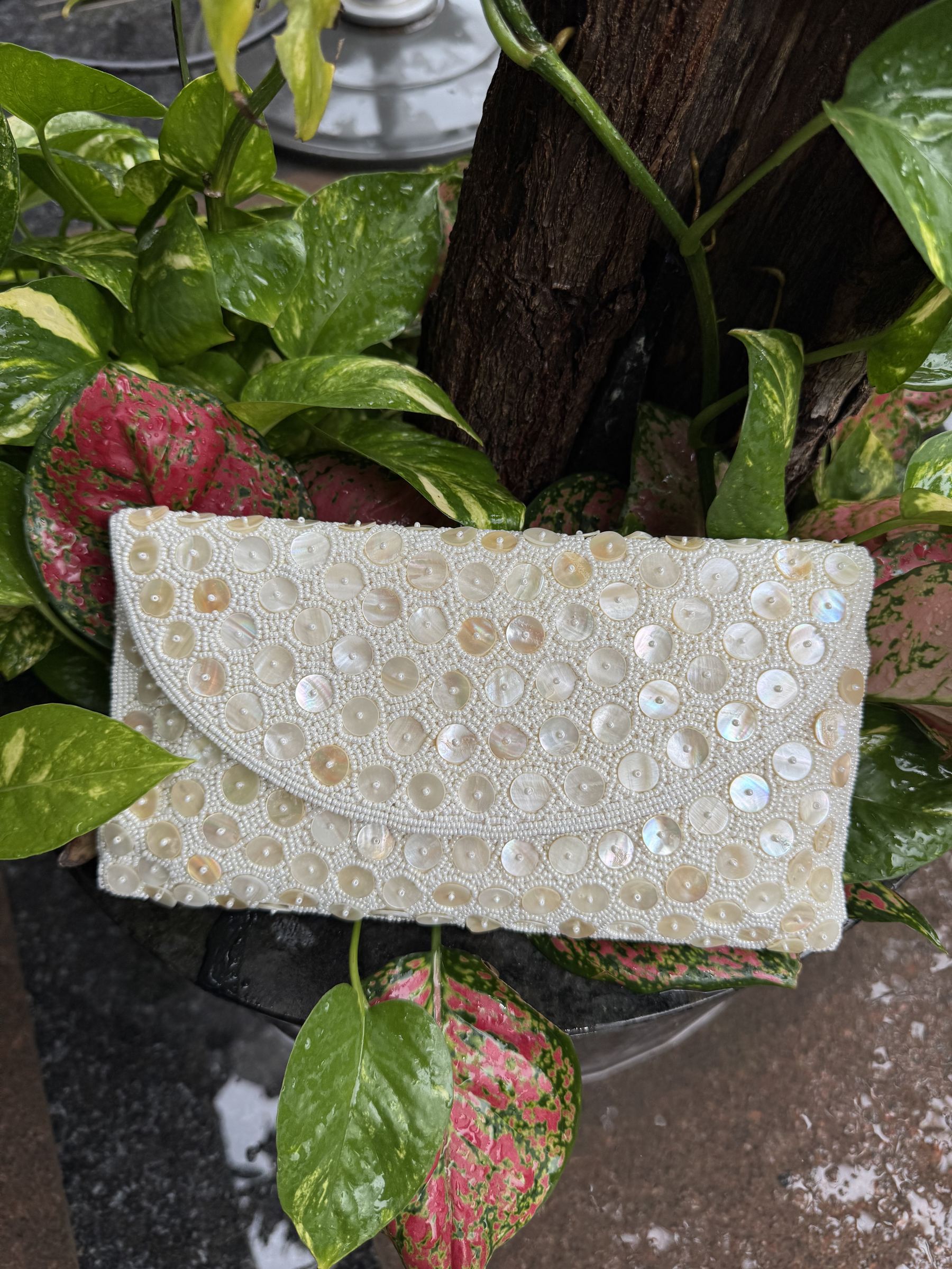 Angled view of the Ocean's Grace bag with its silver-tone metal sling chain attached.