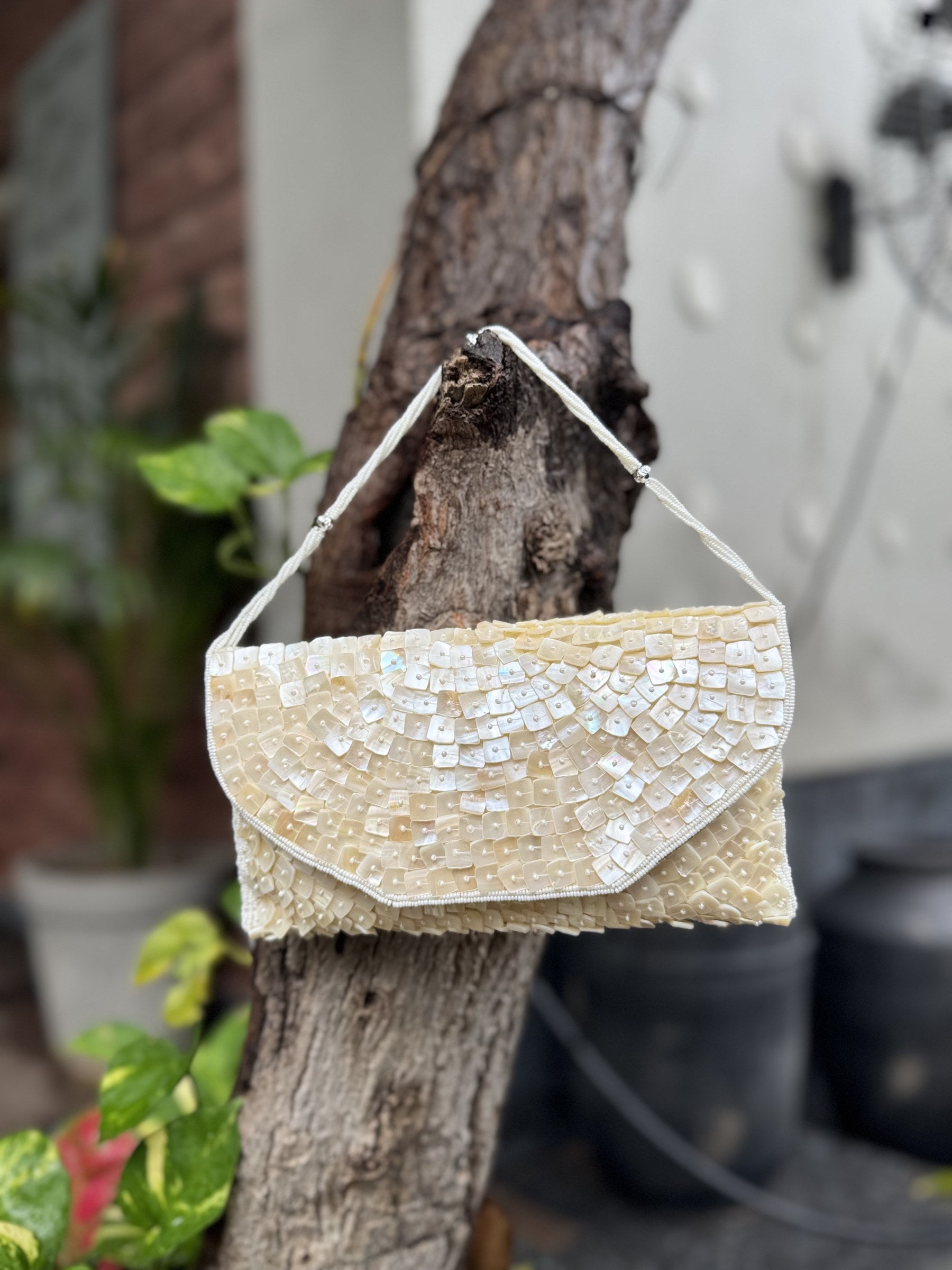 The Ocean's Grace clutch styled handheld, highlighting its sleek profile and pastel color coordination.