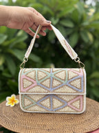 Front view of the Pastella Clutch, showing its soft pastel shimmer fabric and gold frame clasp.