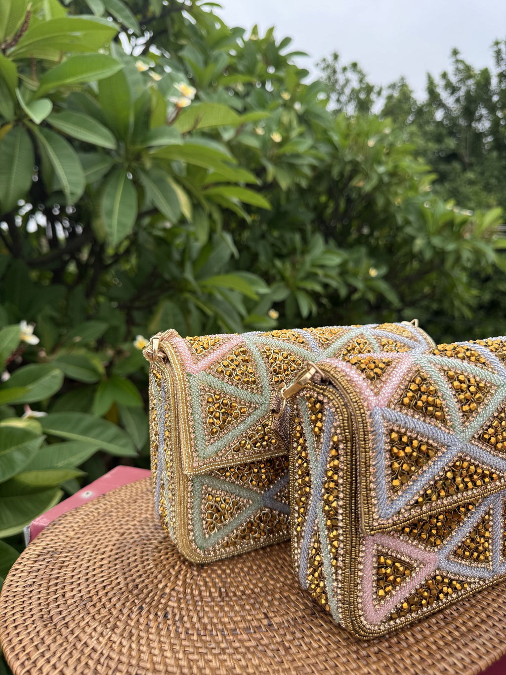 Model carrying the Pastella clutch by its gold chain, displaying the shoulder drape option.