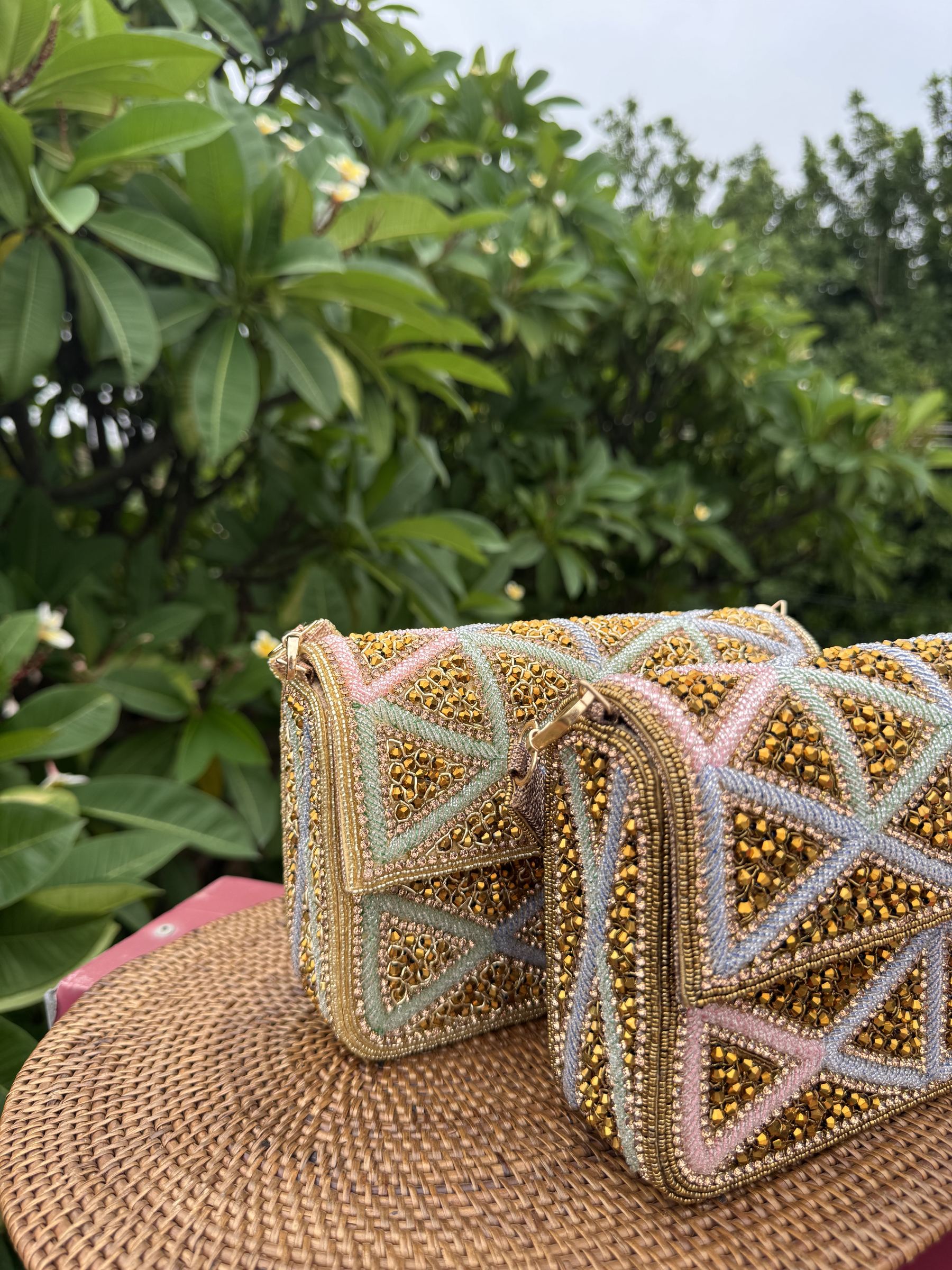 Model carrying the Pastella clutch by its gold chain, displaying the shoulder drape option.