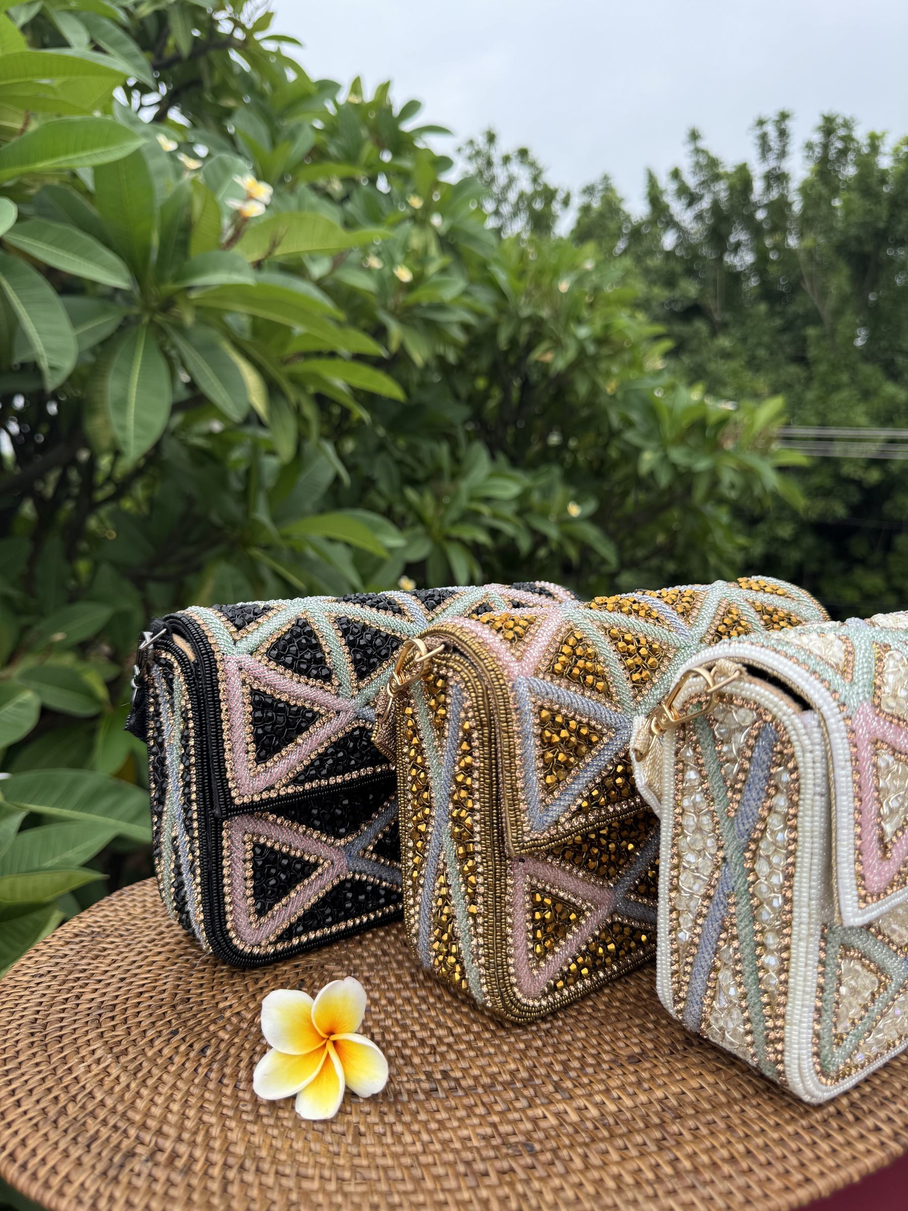 Flat lay of the Pastella clutch with matching jewelry and cosmetics.