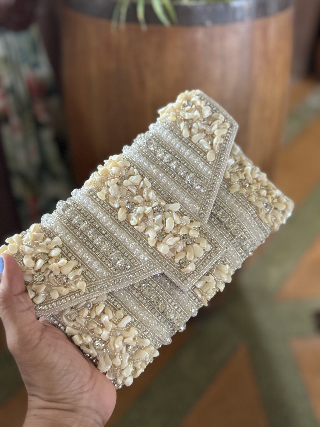 Lifestyle layout of the Riwayat Fold bag styled next to gold jewelry and bridal wedding wear coordinates.